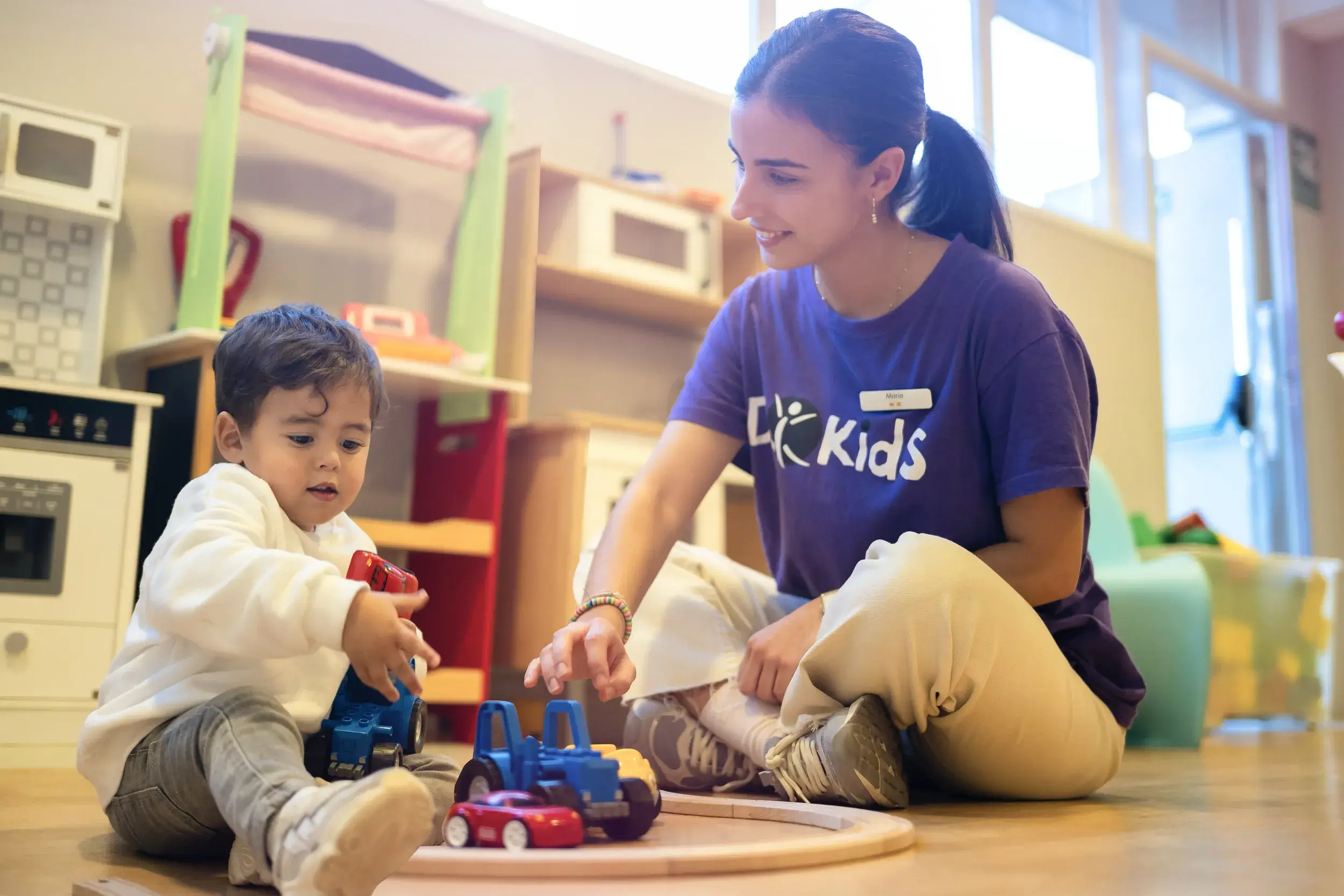 A baby with a DL Kids team member in the creche