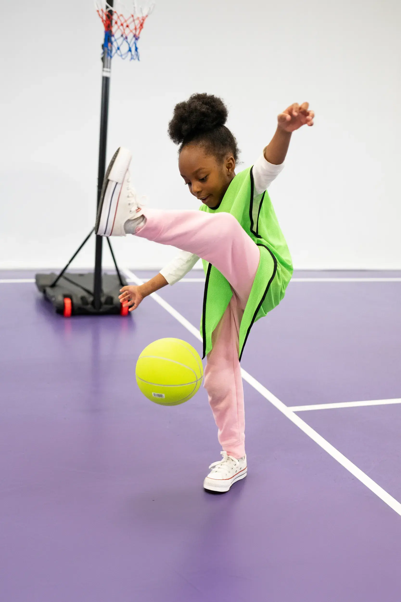 A girl bouncing a ball under her leg