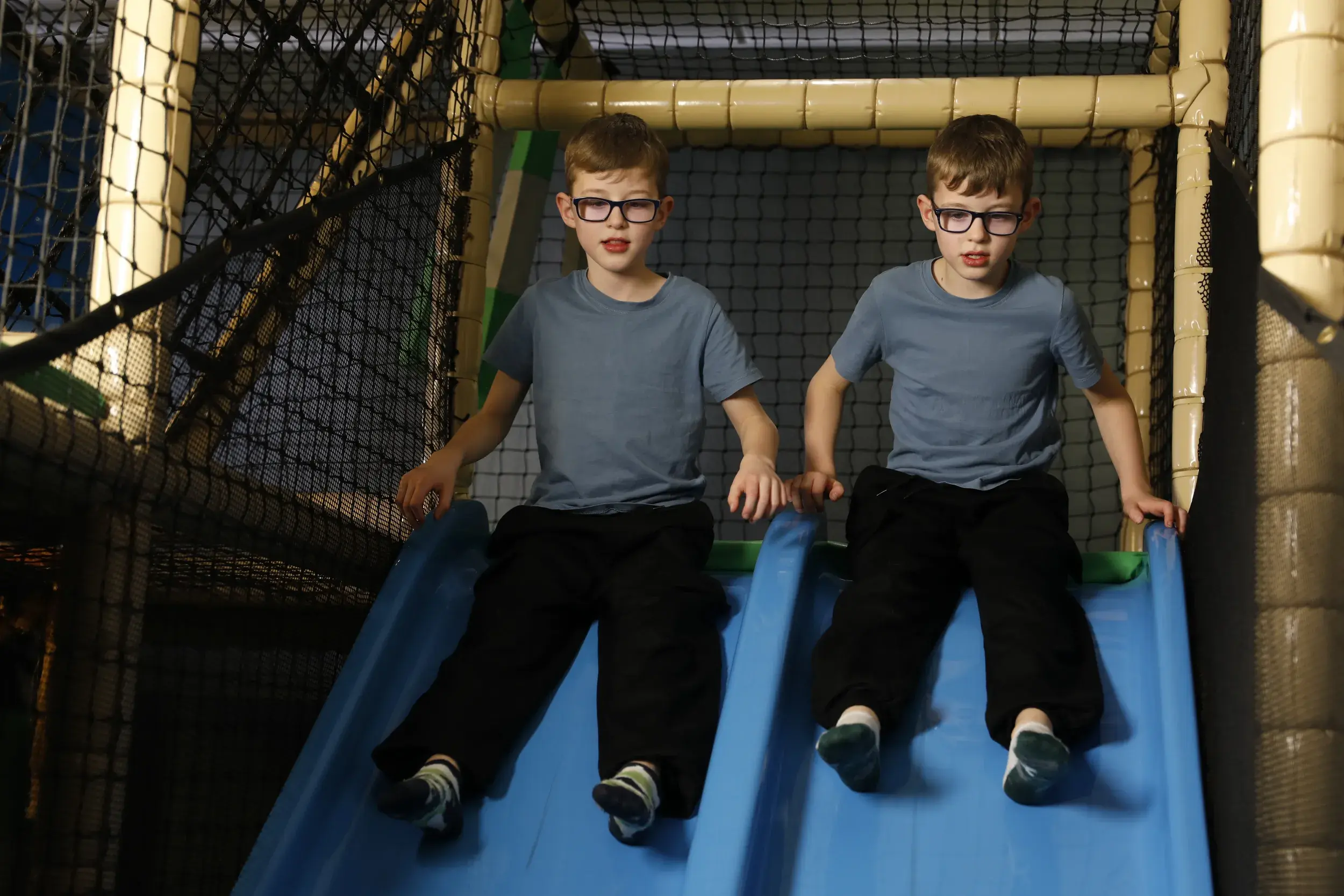 Two twin boys at the top of a slide