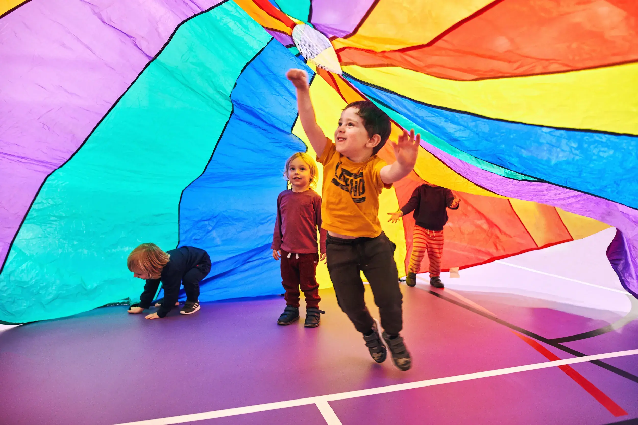 Children playing under a multicoloured tent