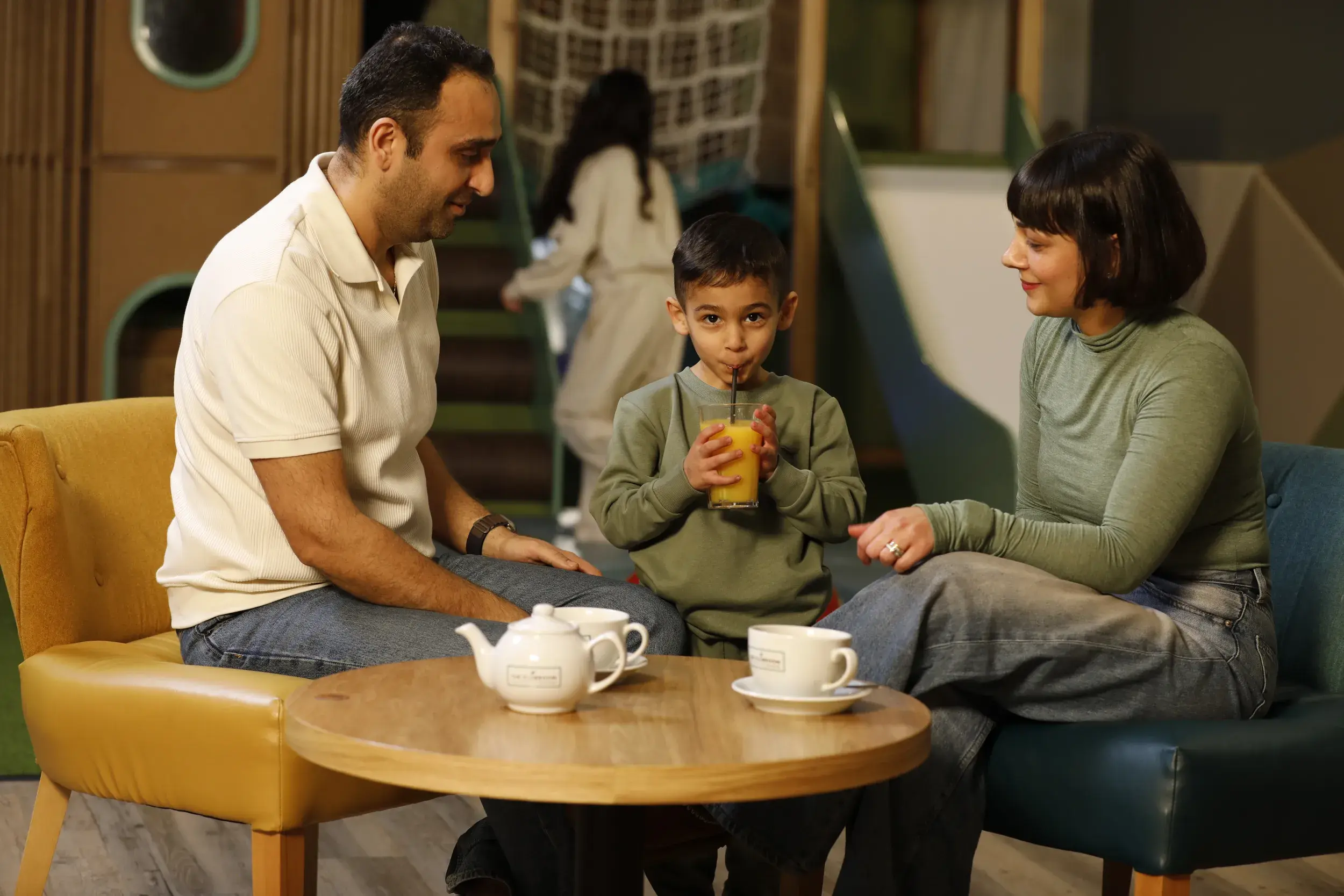 A family enjoying a drink together in the clubroom