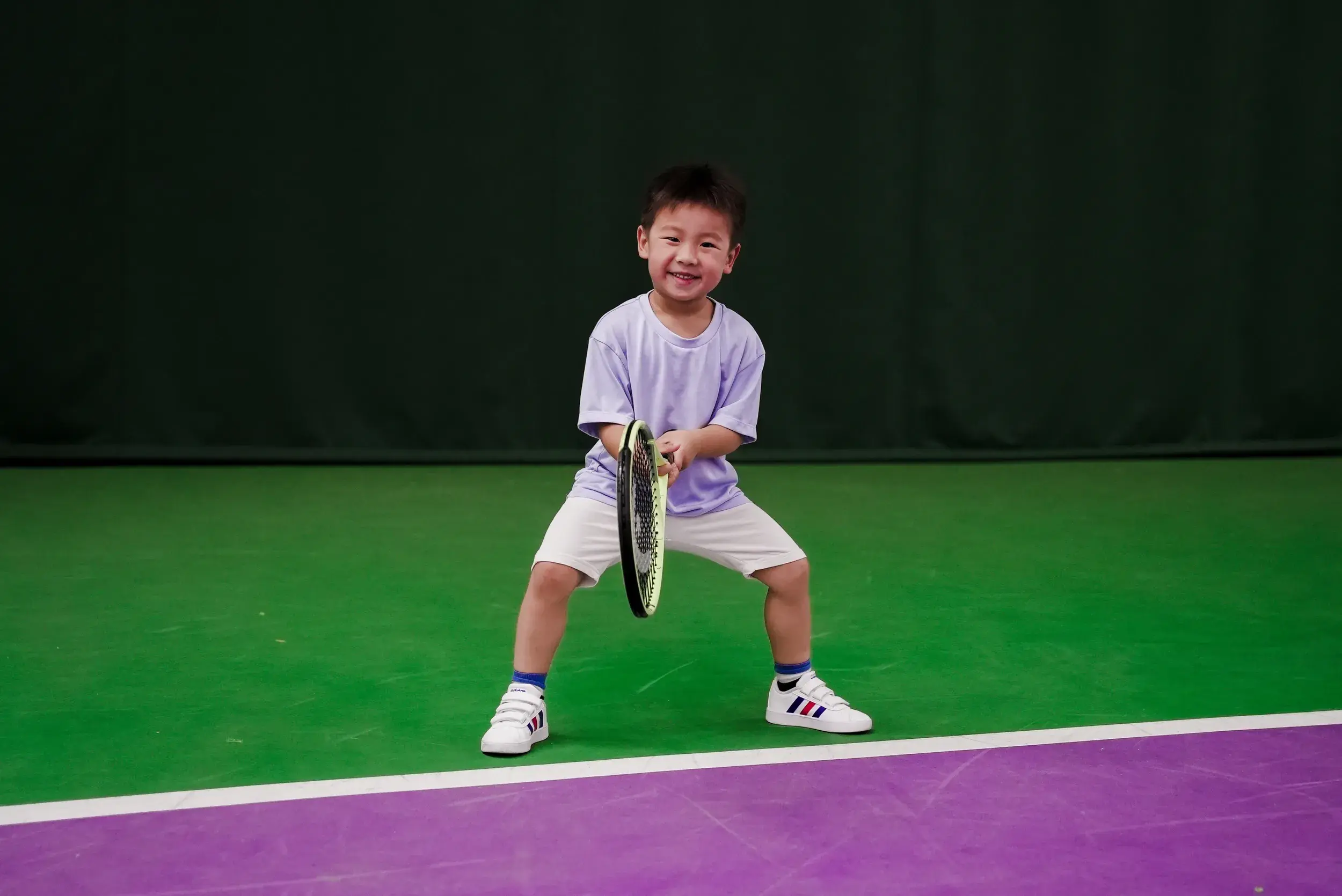 A young boy holding a tennis racquet