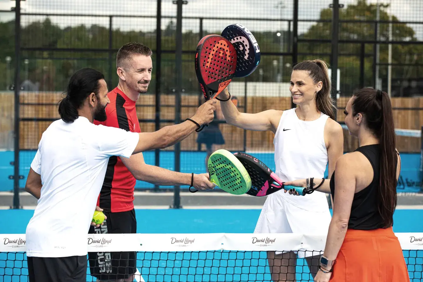 4 people holding padel rackets